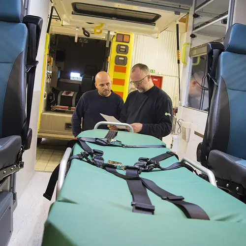 Två män som pratar utanför en ambulans